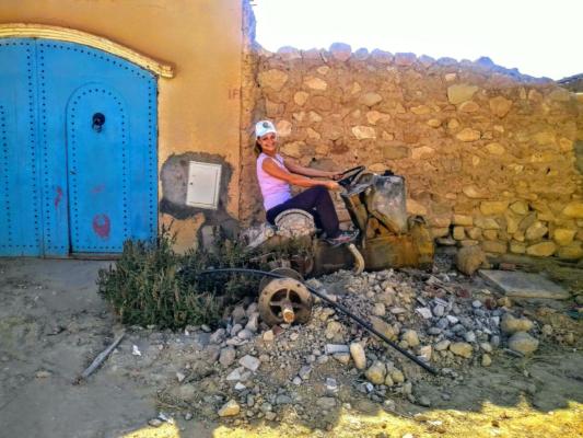 Researcher Franzi riding on the remains of a tractor a